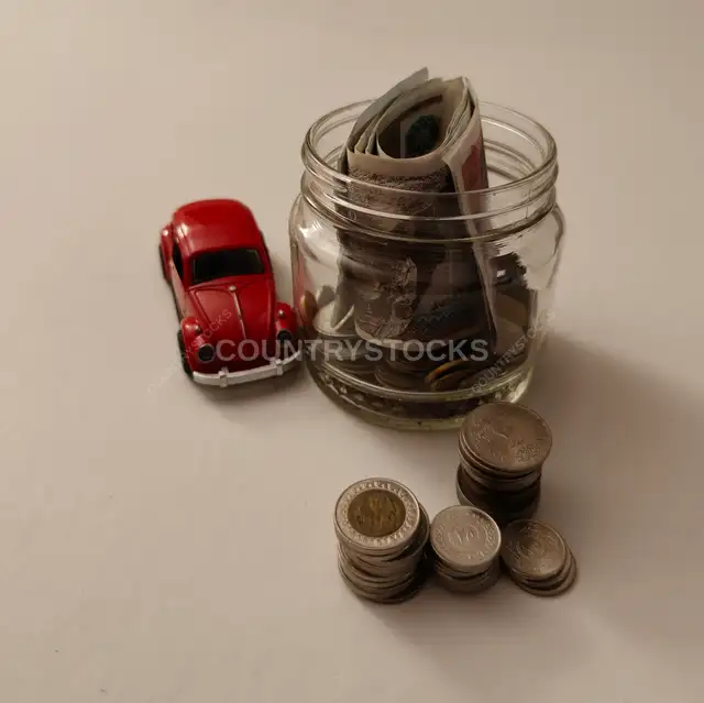 Egyptian Banknotes and Coins in Jar with Red VW Car