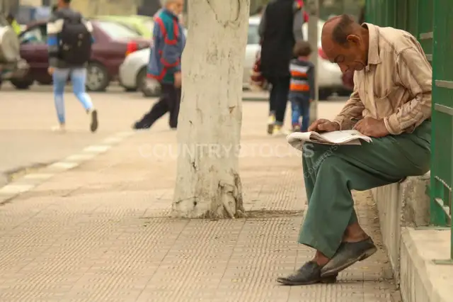 Man Reading a Newspaper in a Street in Cairo, Egypt 4