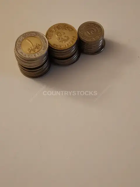 Egyptian Pound Coins Stacked on White Surface