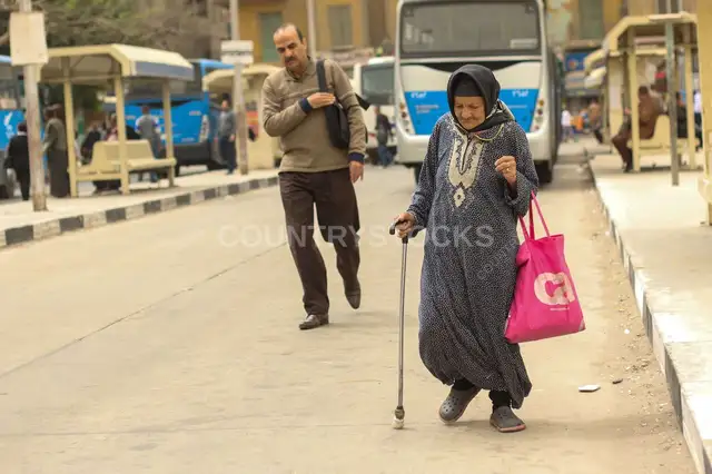 Woman Walking with a Cane Inside a Bus Station in Cairo
