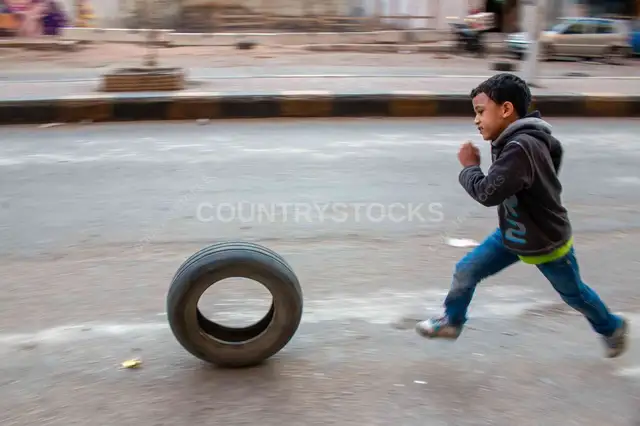 Boy Running with Tire, Sudan Street Cairo