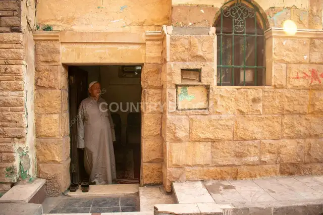 Maqam Caretaker at the Shrine Entrance