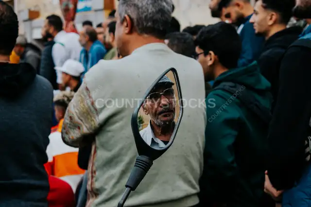 Local Football Spectator Reflected in a Motorcycle Mirror During Al Falaki Tournament