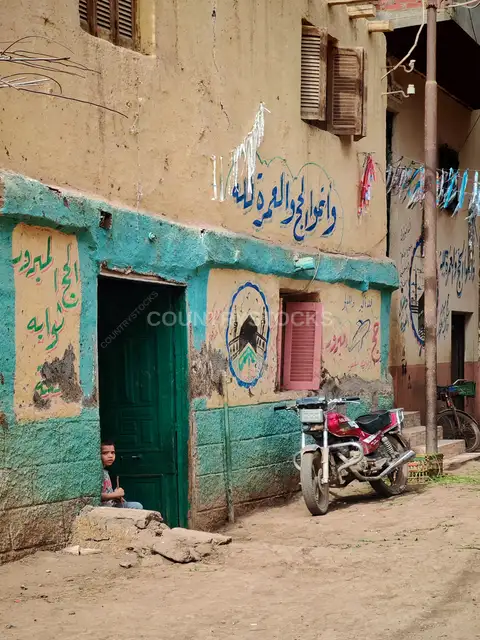A Child Peeking Through an Old Door in Gerees Village, Egypt