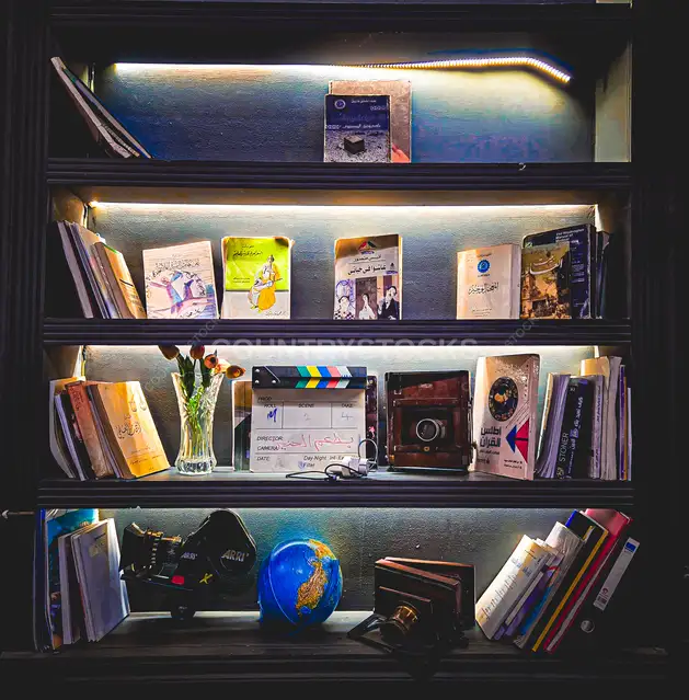 Lit Bookshelf with Books Globe and Film Clapper