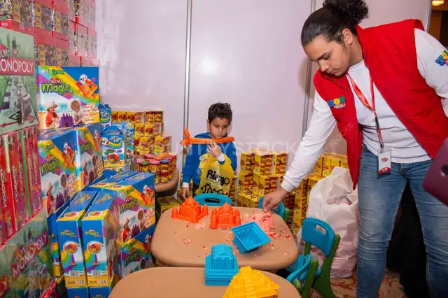Child Playing with Kinetic Sand at Cairo Toy Exhibition