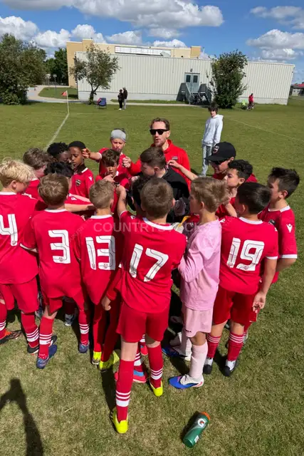 Youth Soccer Team Huddle with Coach Outdoors