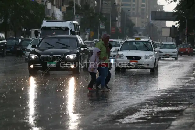 Family Crossing the Street on a Rainy Day in Cairo 1