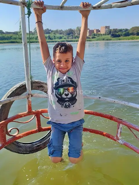 Child Playing on Nile Boat Frame, Al-Qanaater Al-Khayreya