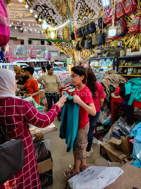 Boy Trying On School Uniform at Cairo Market Stall