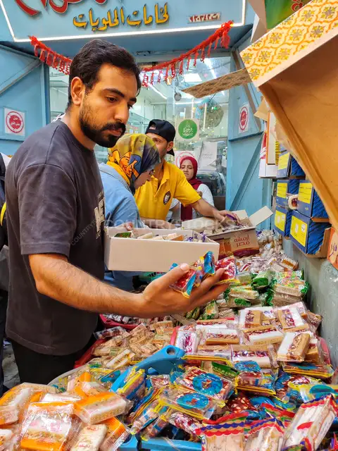 Man Selecting Moulid Candy at Bein El-Haraet Market, Cairo