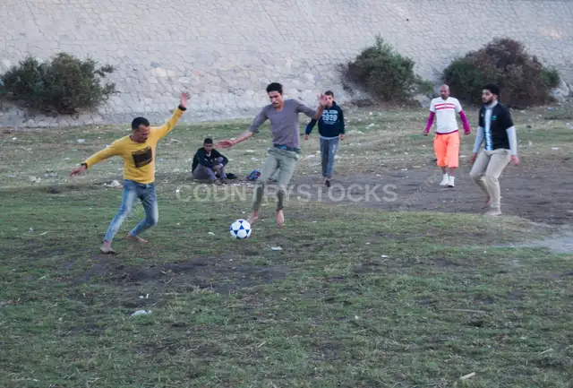 Players Compete for the Ball in a Community Football Match