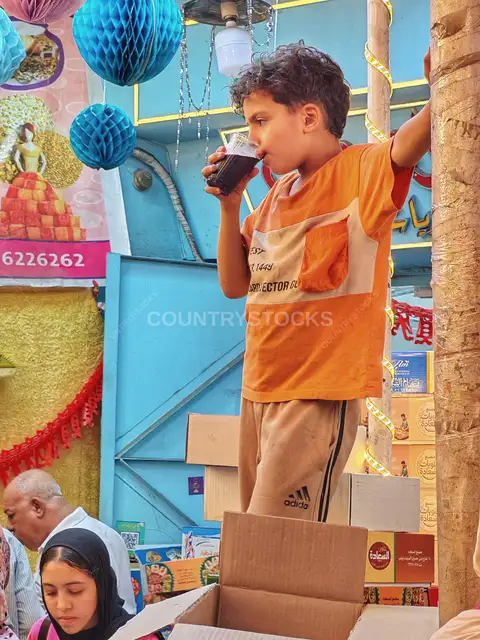 Child Drinking Juice at Moulid Tent, Bein El-Haraat Cairo