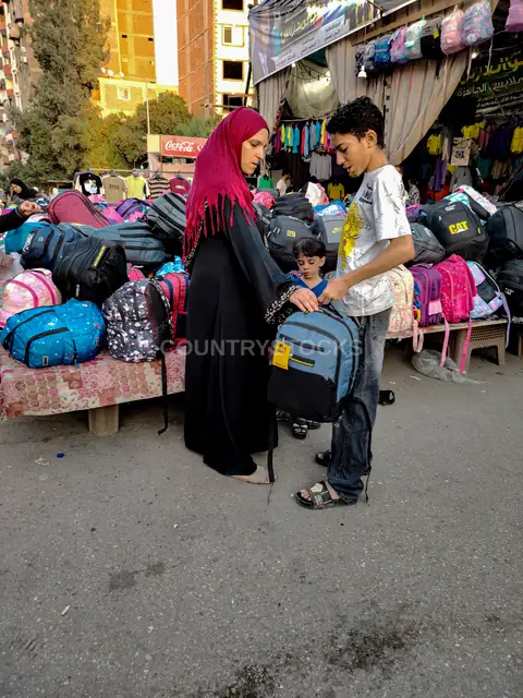 Mother and Children Choosing School Bag, Cairo Market
