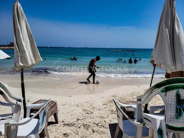 شاب يلعب كرة القدم على شاطئ مرسى مطروح
