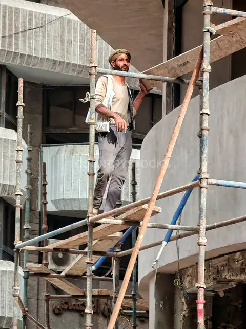 Egyptian Construction Worker Standing on Metal Scaffolding