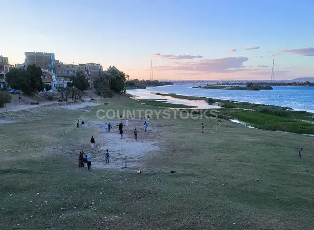 تجمع الأهالي على ضفاف نهر النيل وقت الغروب في قنا، مصر