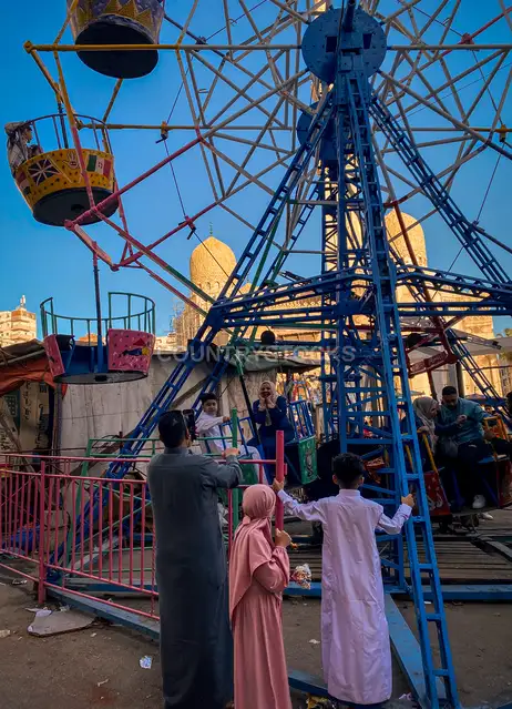 عيلة بتتفسح وأطفال على مراجيح المولد في العيد