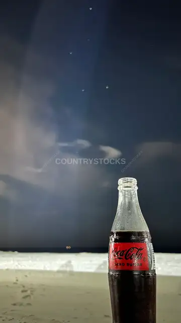 زجاجة كوكاكولا على الشاطئ ليلاً، الساحل الشمالي