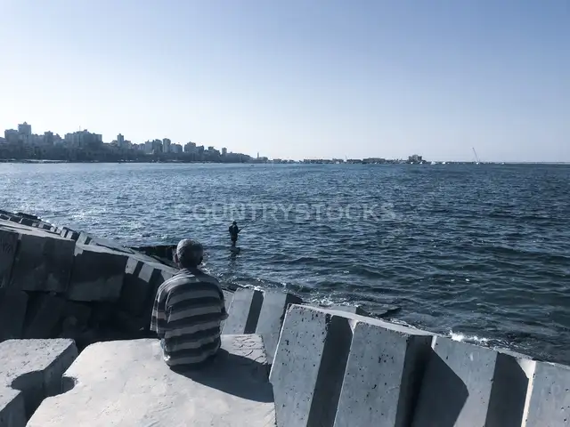 رجل جالس على الكورنيش البحري في الإسكندرية