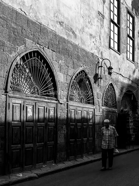 رجل مصري يمشي في شارع الأشراف بالقاهرة أبيض وأسود