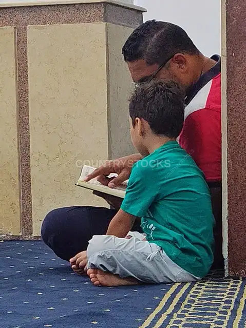 Father Teaching Child Quran Reading in Mosque