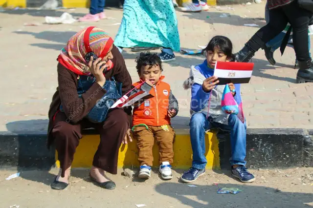 أم وأطفال شايلين العلم المصري في شارع القاهرة