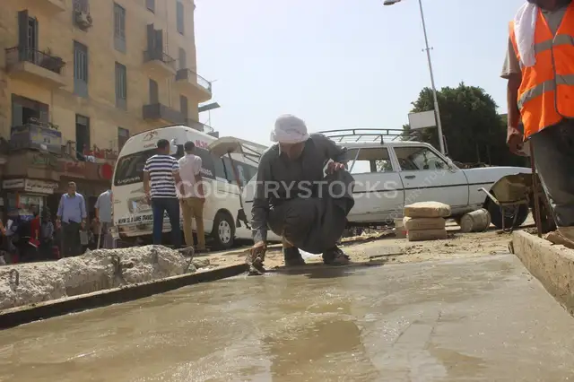 عمال شارع بيصلحوا رصيف في ميدان رمسيس بالقاهرة نهاراً