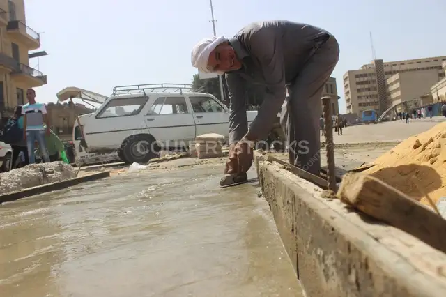عامل شارع بيصلح رصيف نهاراً في القاهرة