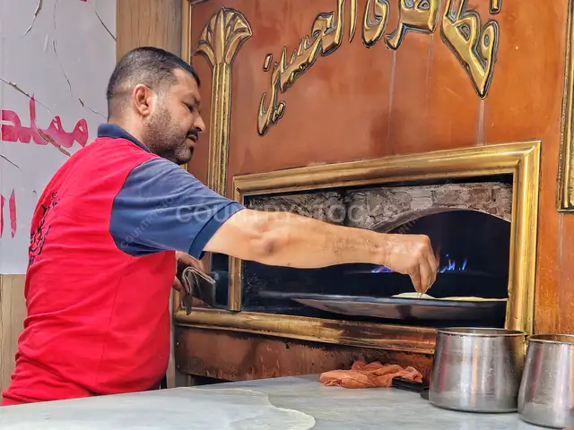 خباز يُدخل عجين البلدي في فرن الحسين، القاهرة