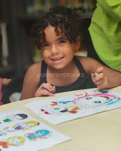 طفلة تبتسم أثناء تلوين الرسومات في مكتبة مصر الجديدة