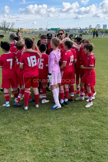 Youth Soccer Team Huddle with Coach Outdoors 2