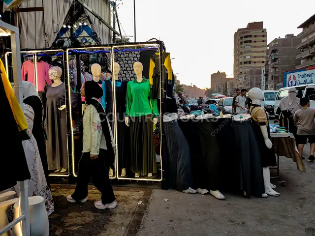 فتاة تختار زيها المدرسي في سوق الشرفا بالقاهرة
