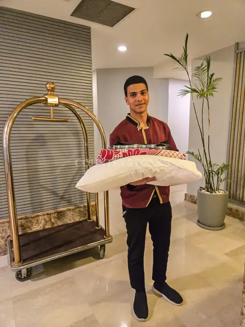 بوي فندق يحمل وسائد في لوبي فندق بالقاهرة