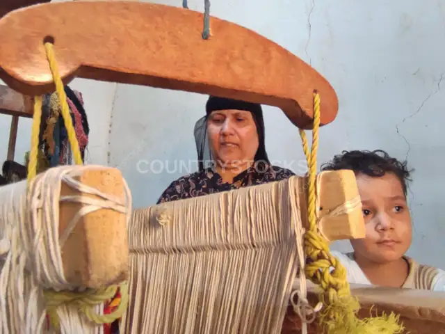 امرأة مصرية وطفل عند نول خشبي تقليدي في الجيزة