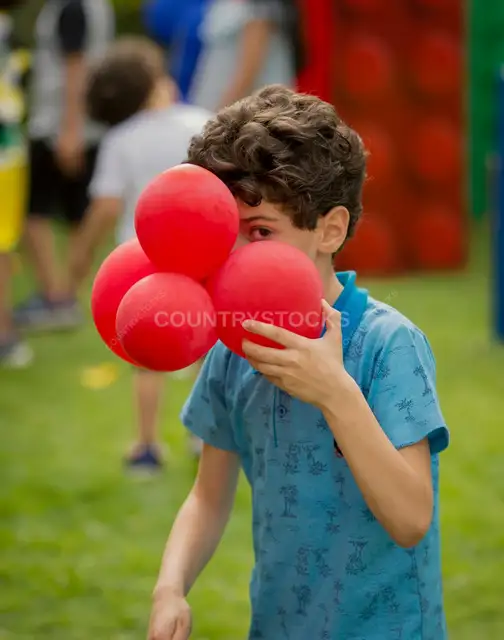 Young Boy Holding Red Balloons Outdoors, Cairo