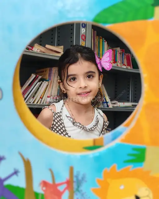 طفلة تبتسم من فتحة دائرية في مكتبة أطفال بالقاهرة