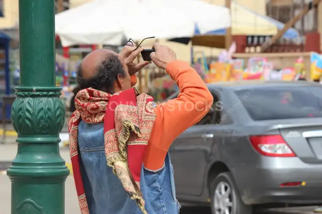 راجل بياخد صورة بموبايله في شارع القاهرة