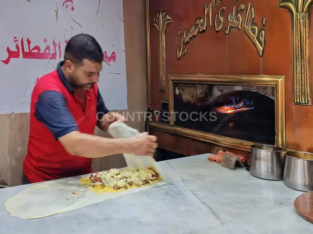 خباز يقفل عجينة الفطير قبل الفرن الحطب - القاهرة