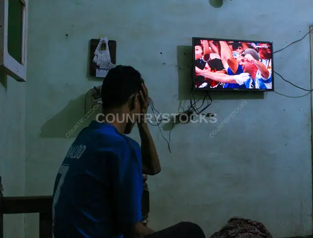 Football Fan Watching Match Alone at Home, Qena