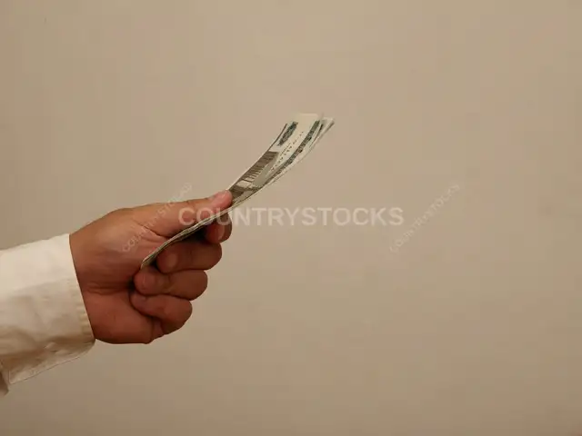 يد تمسك أوراق نقدية مصرية فئة 100 جنيه