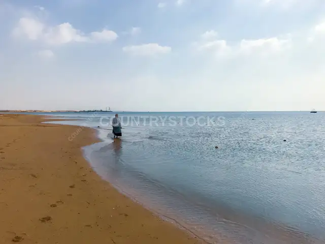 امرأة تمشي على شاطئ العين السخنة، البحر الأحمر