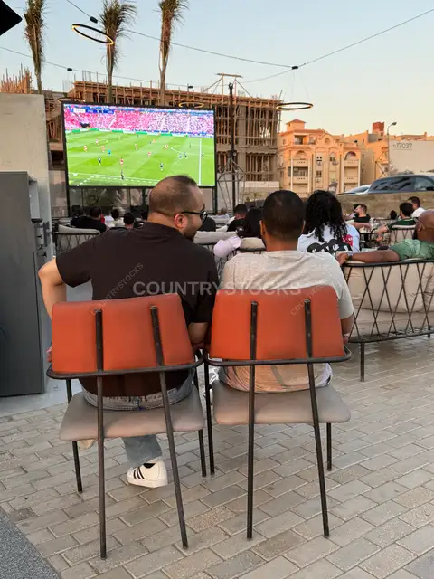 Friends Watching a Football Match at a Café