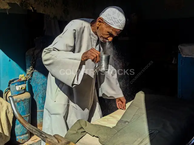 Traditional Tailor Spraying Water, Esna Luxor Egypt