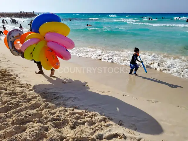 بائع العوامات وطفلة على شاطئ الأبيض، مرسى مطروح