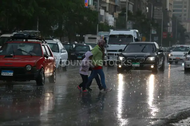 عائلة بتعبر الشارع في يوم مطير في القاهرة 2