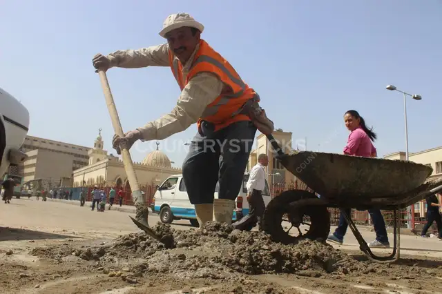 عامل شارع بجارف وعربية نهاراً في القاهرة