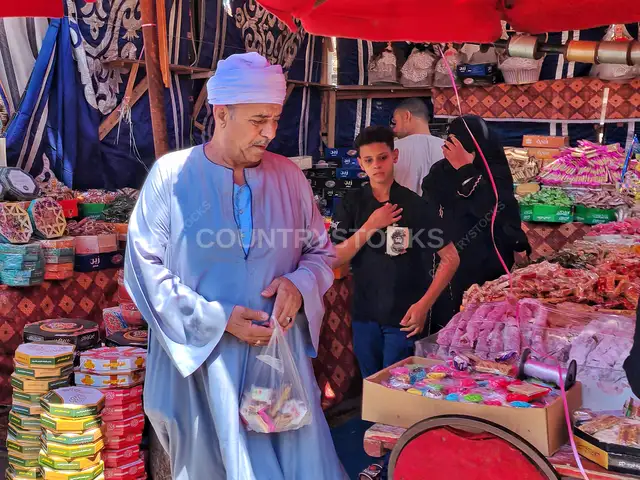 رجل مسن يشتري حلاوة المولد في السيدة زينب، القاهرة