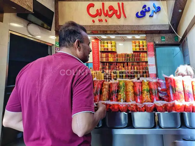 زبون أمام أصناف المخللات في طرشي الحبايب - السيدة زينب