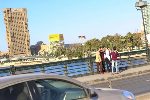 مشاة على كوبري قصر النيل في شتاء القاهرة